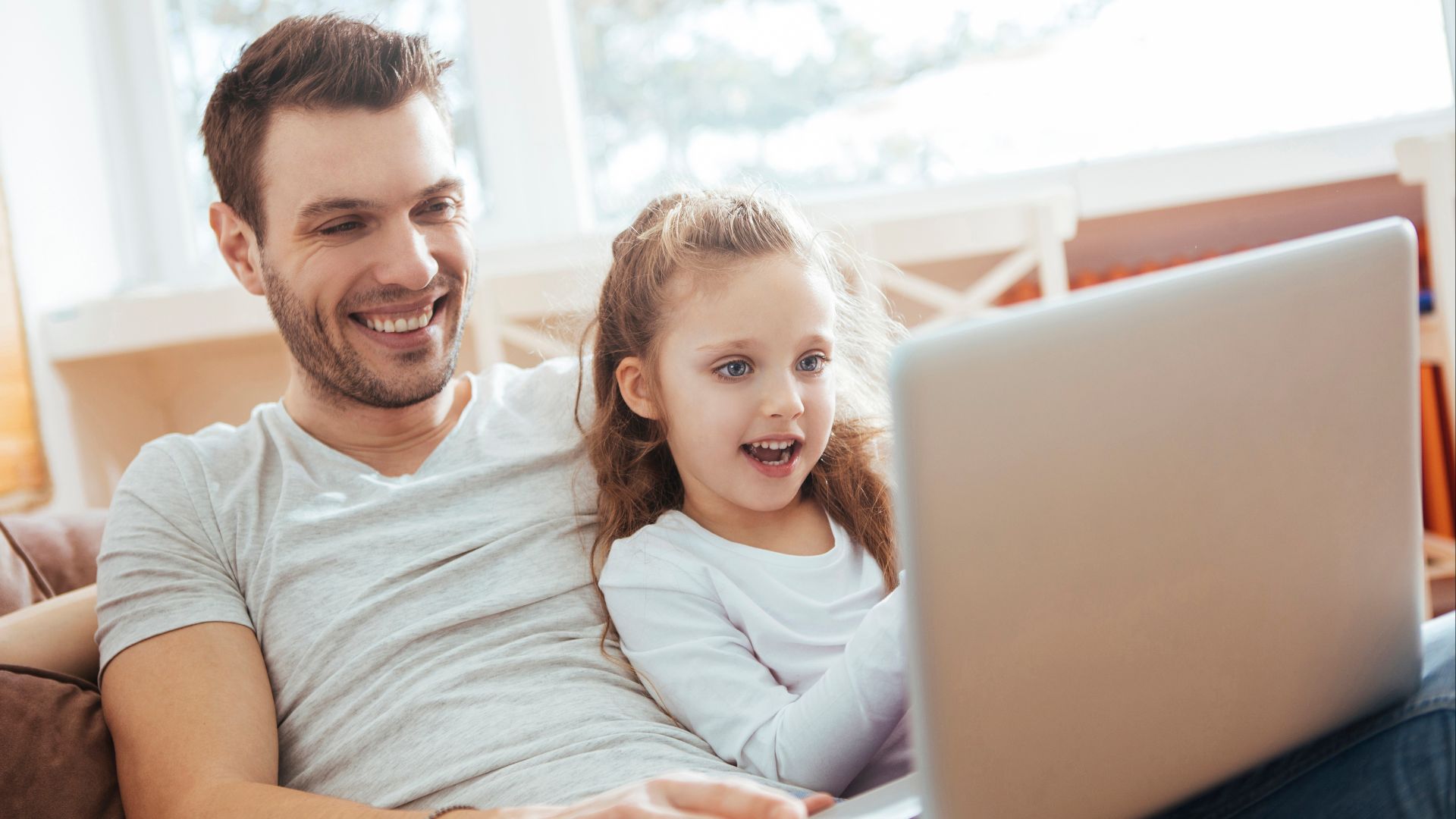 Padre e hija trabajando juntos en computadora